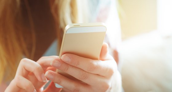 スマートフォンでニュースレターを読む女性